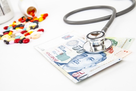 Singapore Health Insurance concept with stethoscope on money isolated on whiteの写真素材