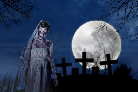 Halloween scene with creepy zombie bride on the dark night at graveyardの写真素材