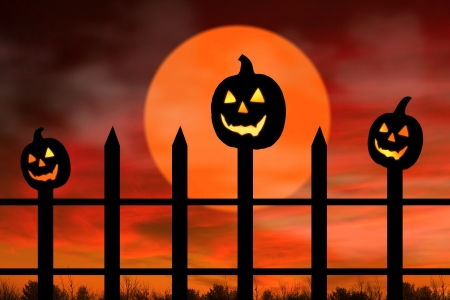 Halloween background with three black pumpkins in the fence glowing.の写真素材