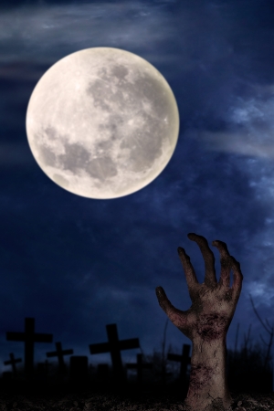 Spooky graveyard with zombie hand coming out of the groundの写真素材