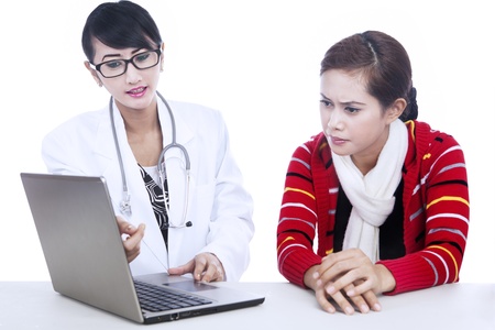 Female doctor explaining a patient illness via laptop isolated in whiteの写真素材