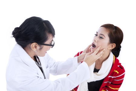 Female doctor checking her patient by asking her to open her mouthの写真素材