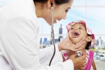 A female pediatrician is checking cute girl patientの写真素材