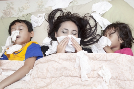 Family is lying on a bed due to flu in winter Family is lying on a bed due to flu in winter