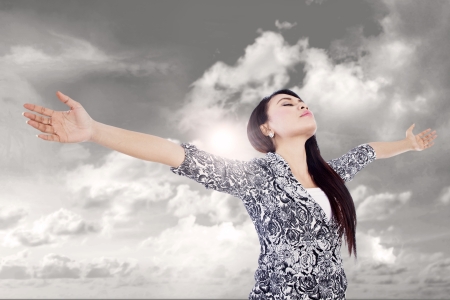 Businesswoman is stretching her arms expressing her winning outdoorの写真素材