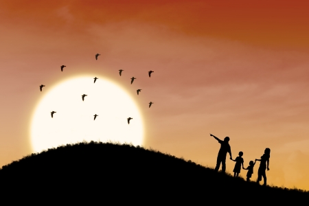 Silhouette of happy family walking up the hill with sunset sceneの写真素材