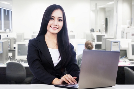 Businesswoman is smiling while working at her officeの写真素材