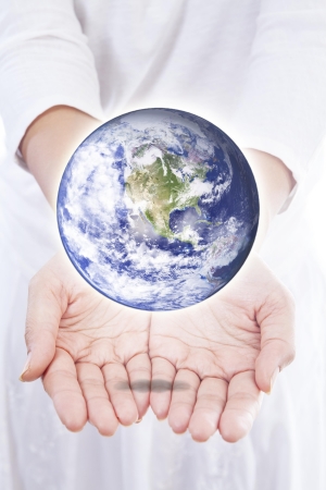 Woman holding planet earth in her hands, isolated on whiteの写真素材