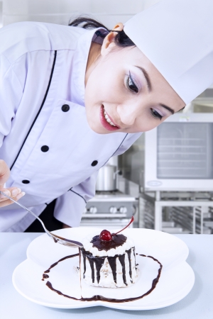 Beautiful chef is preparing a chocolate dessert in the kitchenの写真素材