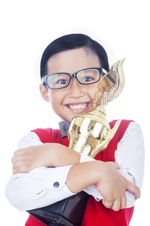 Boy is holding a trophy and proud of his achievement, isolated on whiteの写真素材