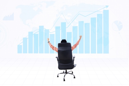 Businessman raising his arms with profit bar chart backgroundの写真素材