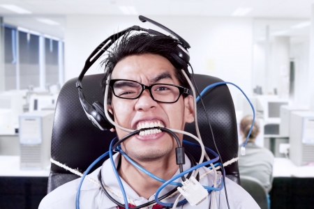 Stress businessman biting cabbles at officeの写真素材