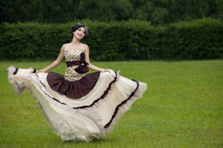 Beautiful woman dancing with formal dress at the parkの写真素材