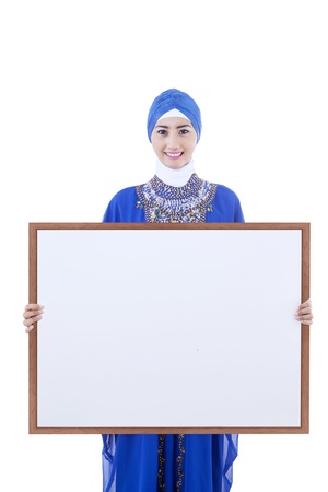 Asian female muslim in blue dress holding blank board , isolated on whiteの写真素材