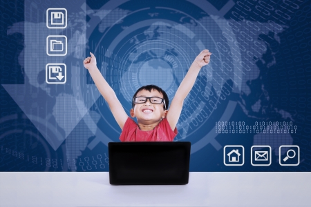 Asian boy winning using laptop on blue world map background