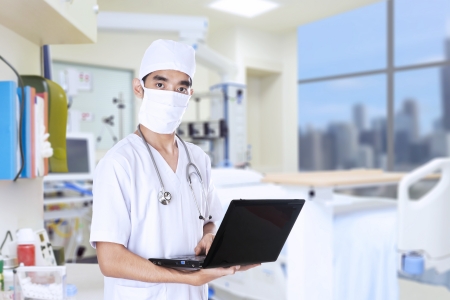 Male doctor with a small laptop computerの写真素材