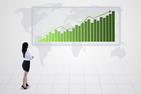 Businesswoman looking at bar chart with increasing trend on whiteの写真素材