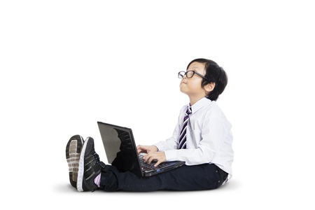 Cute little businessman using laptop on white background