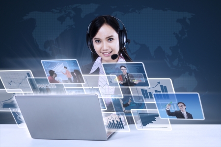 Asian businesswoman working on her laptop with  world map backgroundの写真素材