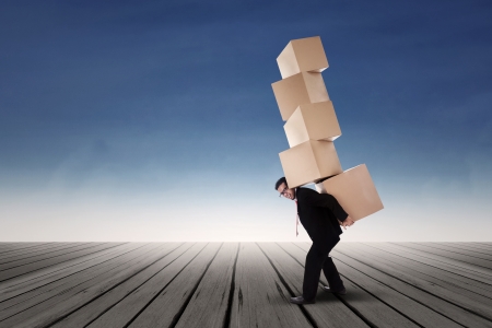 Businessman with stack of boxesの写真素材