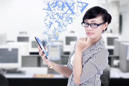 Thoughtful asian businesswoman with digital tablet at the officeの写真素材