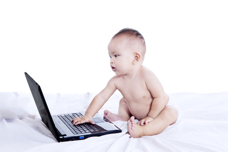 Little baby is typing on the laptop computerの写真素材