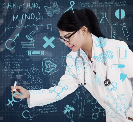 Asian female doctor drawing on transparent screen with blue backgroundの写真素材