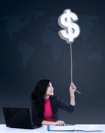 Happy businesswoman grabbing dollar profit from global businessの写真素材