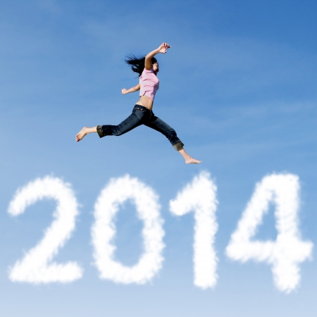 Excited asian woman is jumping with new year 2014 on the skyの写真素材