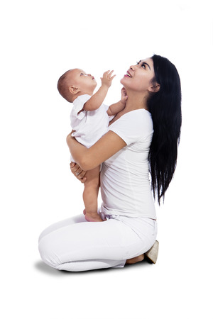 Portrait of mother with her adorable baby isolated on white backgroundの写真素材