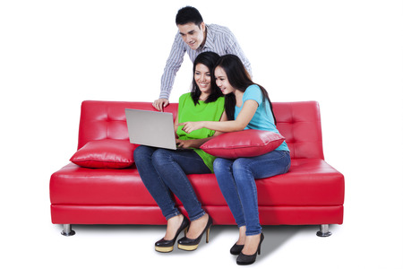 Group of young people using a laptop - isolated on white backgroundの写真素材