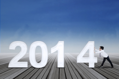 New business arrangement concept with a little businessman arrange new year of 2014の写真素材