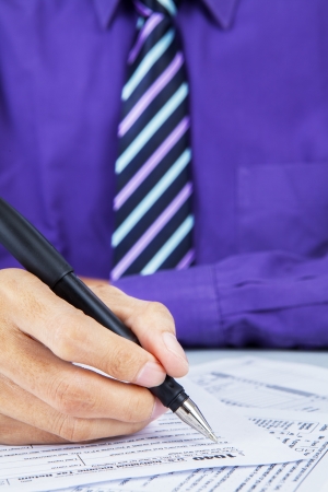 Close up of businessman filling the tax formの写真素材