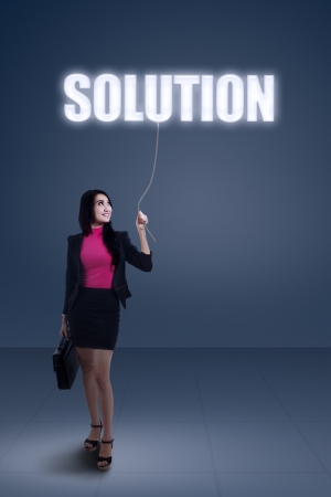 Beautiful young businesswoman holding a solutionの写真素材