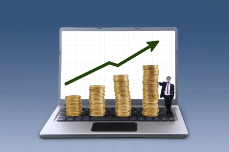 Business manager standing next to profit growth coins chart on blue backgroundの写真素材