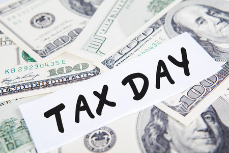 Taxes concept with money and text of tax dayの写真素材