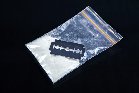 Razor Blade closeup with cocaine isolated on black with reflectionの写真素材
