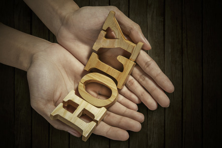 Man holding pray word in palm with wooden table の写真素材