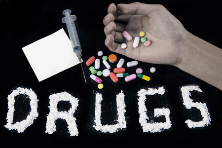 No drugs concept - closeup of a text of drugs, pills, syringe, hand, and notice