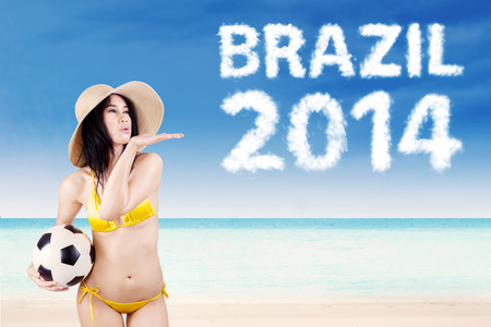 Woman with a soccer ball at beachの写真素材