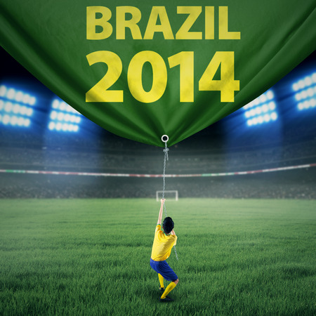 Portrait of soccer player pulling a banner of football competition. Isolated on whiteのeditorial素材