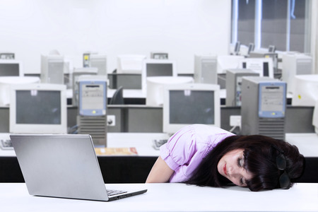 Tired businesswoman sleeping on her desk in the officeの写真素材