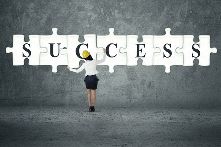 Businesswoman builds or completes a big puzzleの写真素材