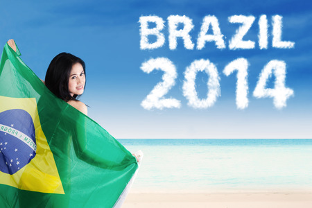 Portrait Of A Happy Pretty Woman Holding Brazilian Flagの写真素材