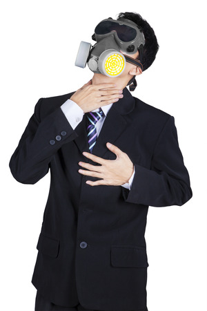 Pollution concept: portrait of businessman in a gas mask holding his neck and heartの写真素材