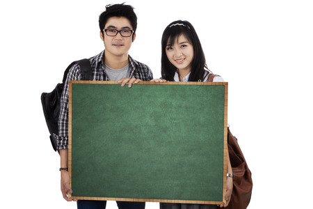 Back to school concept with two students holding a small blackboardの写真素材