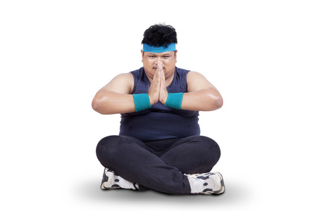 Overweight man doing meditation, isolated on white backgroundの写真素材