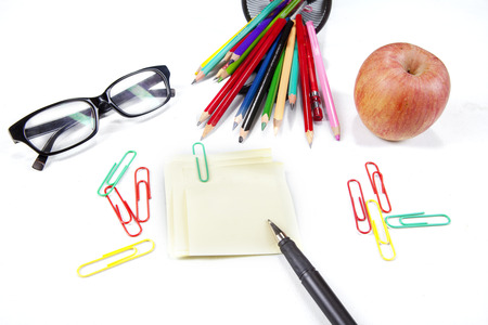 Sticky note, pen, glasses, crayon, and apple, isolated on white backgroundの写真素材