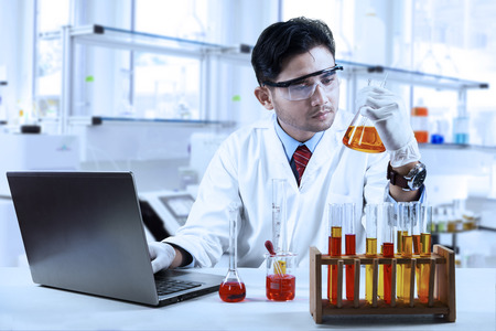 Asian chemist working in laboratory and doing research