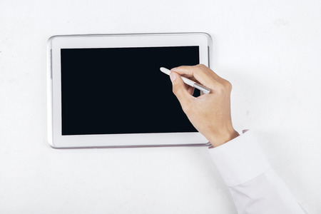 Close up of businessman hand using stylus pen for touching the digital tablet screen